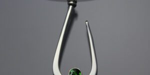 Silver fish hook style pendant with green gem by John Tzelepis
